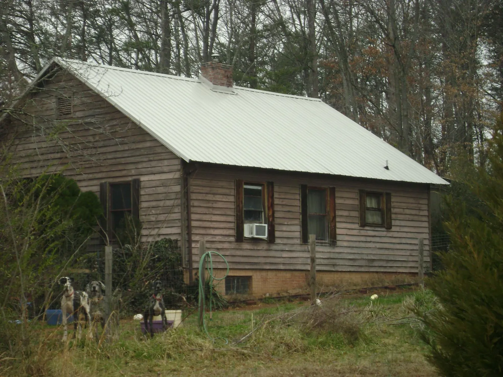 White metal roof on an old wood sided farmhouse, from a Metal Roof Installation job in Mount Freedom